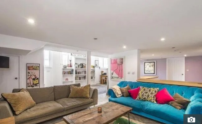 Untuk memberi kesan ceria, dia menambahkan sentuhan warna bold pada sofa dan bantal hias di ruang tamu. Foto: Rightmove.co.uk