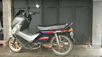 Secara ubahan, modifikasi ini hampir mengubah seluruh area depan Honda Astrea Grand. Mulai dari fork bagian bawah, pelek, ban, headlamp, hingga area setang, dan spion. Agar tidak mengganggu pengoperasian pedal transmisi dan tuas rem belakang, bagian bodi samping sedikit dipapas. Selain itu juga dilakukan penyesuaian untuk kabel bodi, supaya kelistrikan bisa berfungsi normal. Foto: Pool (Screenshot Youtube Bapak Mustofa Kepala Jenggot)