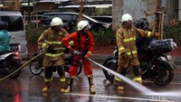 Petugas membersihkan Jalan Prof Dr Satrio Kunigan, Jakarta dari lumpur sisa banjir.