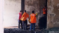 Setelah mengambil sejumlah benda hangus ke dalam plastik, polisi bergerak masuk ke bangunan ruko mebel, tempat dimana dua perempuan dan seorang balita terjebak hingga tewas.