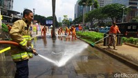 Trotoar dibersihkan dengan cara disemprot dengan air.