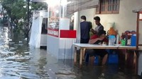Meski banjir menghadang, kalau soal makan masakan panas harus tetap jalan. Seperti yang terjadi pada foto yang satu ini. Pembeli tampak fokus menghabiskan makanannya, meski kakinya sudah terendam banjir. Foto: Istimewa