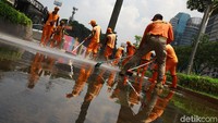 Petugas Penanganan Sarana dan Prasarana Umum (PPSU) atau Pasukan Oranye dan Pemadam Kebakaran membersihkan trotoar di depan Kemendikbud hingga FX Sudirman, Jakarta Pusat, Rabu (18/12/2019).