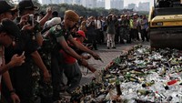 Ribuan botol miras tersebut dikumpulkan menjadi satu sebelum dihancurkan dengan menggunakan buldozer.