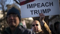 Warga membawa serta sejumlah poster berisi tuntutan untuk memakzulkan Trump saat melakukan aksi unjuk rasa di depan kantor Kongres Amerika Serikat, Rabu (18/12) lalu. Drew Angerer/Getty Images.