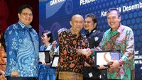 Menteri Koperasi dan UKM Teten Masduki (tengah) memberikan penghargaan kepada Direktur Utama Perum Jamkrindo  Randi Anto (kanan) dan, disaksikan Menteri Koordinator bidang Perekonomian Airlangga Hartarto (kiri) di Kantor Kementerian koordinator Bidang Perekonomian Kamis (19/12). Foto: dok. Kemenkop UKM