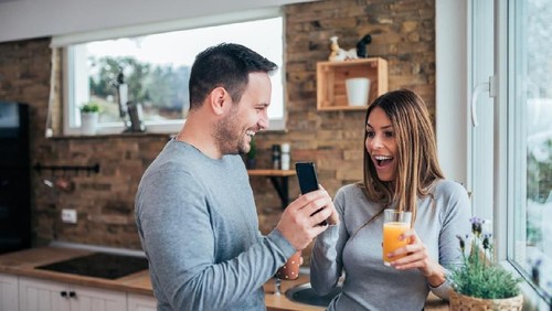 Profile side view portrait of two nice lovely attractive sweet cheerful cheery people husband wife sitting on divan discussing news in white light interior room