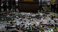Sebuah buldozer melindas ribuan botol miras yang berhasil diamankan oleh aparat keamanan.