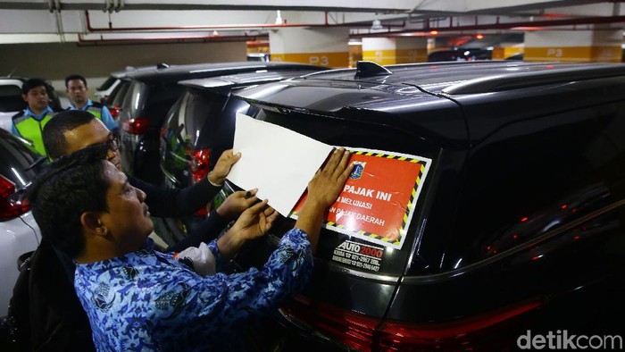 Badan Pajak dan Retribusi Daerah (BPRD) DKI Jakarta melakukan razia door to door di Mal Pacific Place, Jakarta. Mobil yang menunggang pajak langsung ditempeli stiker.