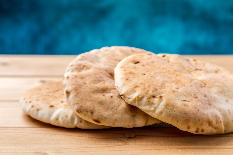 Pita, Arabic bread, soft baked flatbreads on wooden background, selective focus