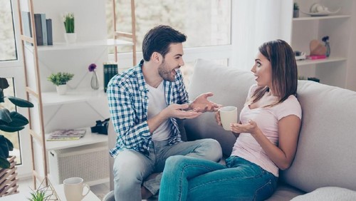 Profile side view portrait of two nice lovely attractive sweet cheerful cheery people husband wife sitting on divan discussing news in white light interior room