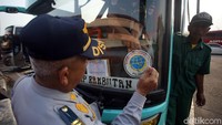 Petugas Dishub DKI menempelkan stiker usai memeriksa kelaikan bus di Terminal Kampung Rambutan, Jakarta.