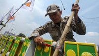 Seorang petugas melepas ikatan tiang bendera parpol di pagar flyover.