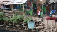 Seorang penjual sedang menarik tali untuk mengarahkan ember kepada pembeli yang berada di pinggir Kali Mampang, Jakarta, Jumat (20/12/2019).