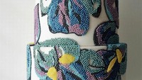 Dihias dengan bentuk bunga menggunakan mutiara beragam warna ini terlihat sangat cantik karena penuh warna. Kue 3 tingkat dengan dasar putih ini sangat terlihat artistik. Foto: Instagram @albenacakedesign