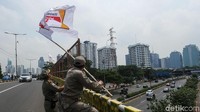 Satpol PP mencopot bendera partai politik yang berkibar di pinggir jalan kawasan Senayan.