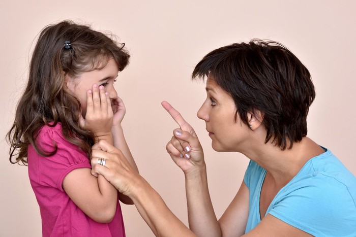 Angry mother scolding a scared daughter