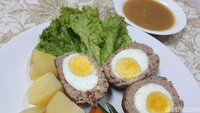 Telur rebus utuh dibalut dengan adonan daging menjadi bistik telur yang istimewa. Ditambah saus cokelat dan sayuran, sajian spesial ini enak dimakan bareng keluarga. Resep lengkapnya ada di sini. Foto: dok. detikFood