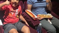 Bocah ceria ini ternyata hobi nonton bioskop. Saat menyaksikan Spider-Man Far from Home, Ryan pesan hot dog untuk disantap sambil nonton. Foto: Instagram ryantoysreview