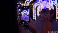 Seorang pengunjung berfoto dengan latar kerlap-kerlip lampu hias yang menawan di salah satu area pusat perbelanjaan tersebut.