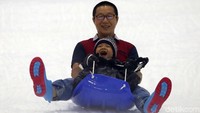 Seorang anak didampingi dengan orang tua nampak asyik bermain selucur es di Trans Snow World Bintaro.