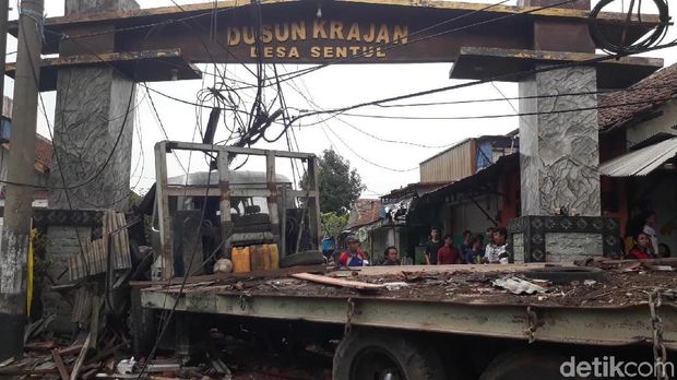 Truk muat ekskavator nyantol di gapura/