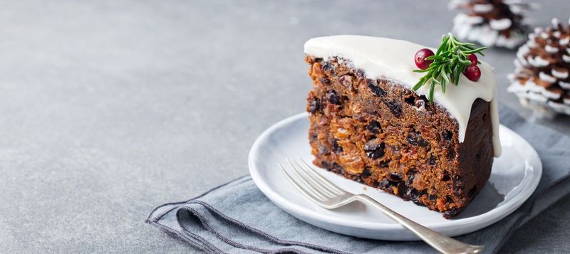 Christmas fruit cake, pudding on white plate. Copy space
