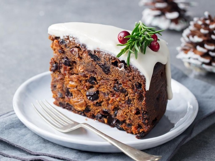 Christmas fruit cake, pudding on white plate. Copy space