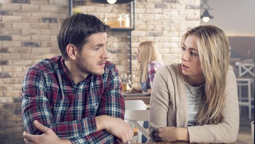 Unhappy young couple arguing standing at house door, angry husband pointing at wife blaming her of problems, conflicts in marriage, bad relationships, man and woman having quarrel or disagreement