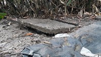Melihat lebih dekat, tutup septic tank itu dalam posisi sedikit terbuka. Tampak pula beberapa sarung tangan elastis berwarna kuning berada di sekitar lokasi tersebut.