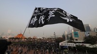Seorang peserta aksi mengibarkan bendera saat ikut serta dalam aksi solidaritas untuk Uighur di Hong Kong, pada Minggu (22/12) lalu.