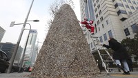 Begini penampakan dekorasi pohon Natal yang dibuat dari puntung rokok di Korea Selatan. Pohon tersebut dibuat di depan kantor korporasi tembakau dan ginseng di Seoul. AP Photo/Ahn Young-joon