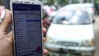 Petugas menunjukkan aplikasi yang digunakan untuk mengecek kendaraan bermotor yang belum membayar pajak.