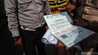 Petugas memeriksa kelengkapan surat kendaraan.