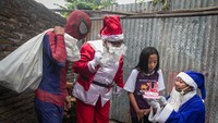 Warga berkostum Sinterklas memberikan kejutan ulang tahun dan hadiah Natal kepada anak di Solo, Jawa Tengah, Selasa (24/12/2019).