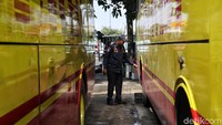 Seorang petugas memeriksa semua ban bus.
