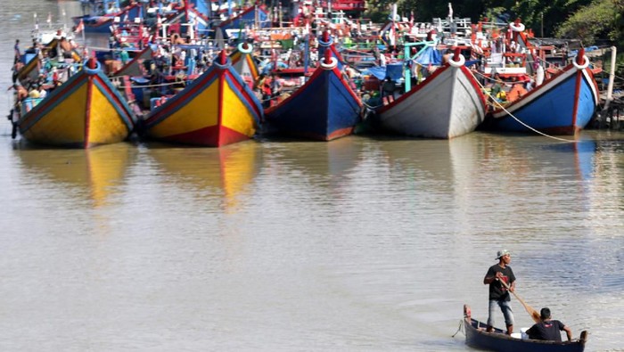 Nelayan membenahi jaring diantara kapal dan perahu yang ditambatkan di Daerah Aliran Sungai (DAS) Krueng Aceh, Peunayong, Banda Aceh, Aceh, Rabu (25/12/2019).  Nelayan Aceh yang diatur dalam hukum adat laut telah menyepakati setiap tanggal 26 Desember wajib libur guna mengenang bencana tsunami dan mendoakan keluarga yang menjadi korban pada peristiwa 15 tahun lalu itu. ANTARA FOTO/Irwansyah Putra/ama.