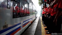 Petugas melepas kereta yang mulai bergerak dari Stasiun Gambir.