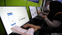 Para penumpang mencetak tiket yang telah dipesan.