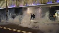 Polisi kemudian melepaskan tembakan gas air mata. AP Photo/Kin Cheung.