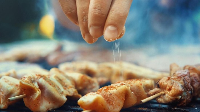Friends making barbecue and having lunch in the nature.