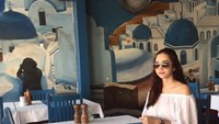 Menggunakan setelan berwarna putih, pose Aura Kasih saat berada di restoran ini terlihat sangat anggun. Tampak senada juga dengan restorannya yang berdominasi warna biru muda dan putih. Foto: Instagram @aurakasih