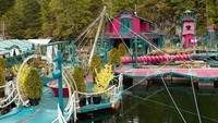Desain rumah ini berwarna magenta dan hijau, sebagian fitur-fiturnya berasal dari barang daur ulang. Salah satunya ada iga ikan paus yang dijadikan gapura (YouTube/FLORB)
