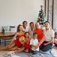 Pesepak Bola Irfan Bachdim dan istrinya Jennifer Bachdim merayakan Hari Natal dengan sederhana bersama keluarga di rumah dengan memakai outfit serba merah dan putih. Tampak kedua buah hati mereka berpose ceria memegang kado Natal. Foto: instagram @jenniferbachdim