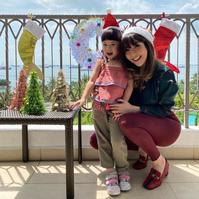 Gisella Anastasia dan buah hatinya, Gempita Nora Marten merayakan Natal di Hotel Shangri-Las Rasa Sentosa Resort & Spa di Singapura. Gisel dan Gempita tampak kompak dengan memakai topi santa. Foto: instagram @gisel_la