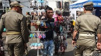Para PKL membawa barang dagangan mereka, ketika mengetahui petugas Satpol PP datang.