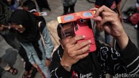 Seorang warga memotret Gerhana Matahari Parsial dari balik kacamata khusus.