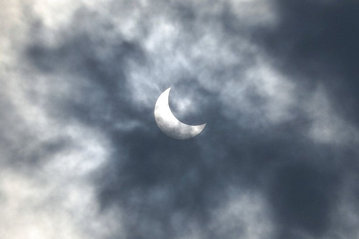 People look up at the sun with protective glasses to watch a solar eclipse from Jakarta, Indonesia, Thursday, Dec. 26, 2019. (AP Photo/Tatan Syuflana)
