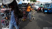 Pedagang gelang menyelamatkan barang dagangannya.