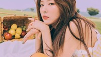 Kang Seul-Gi nampak menawan saat pemotretan bertema piknik. Ia ditemani sekeranjang buah-buahan segar yang juga kelihatan menarik. Foto: Instagram redvelvet.smtown